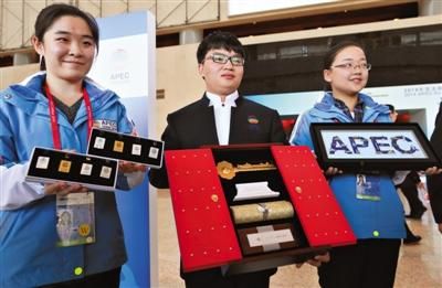 昨日，国家会议中心，志愿者展示APEC纪念徽章(左)、北京城市钥匙(中)和APEC经济体建筑拼图徽章套装(右)。  　　新京报记者 薛珺 摄