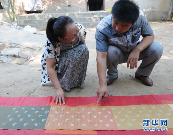 临西县文保所人员在查看康熙圣旨（8月15日摄）。