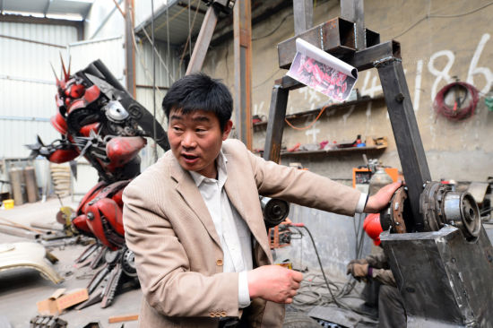 3月27日，在章丘市圣井镇，刘宪会在车间里和团队成员商量“变形金刚”机器人组装细节。摄影：郭绪雷 新华社