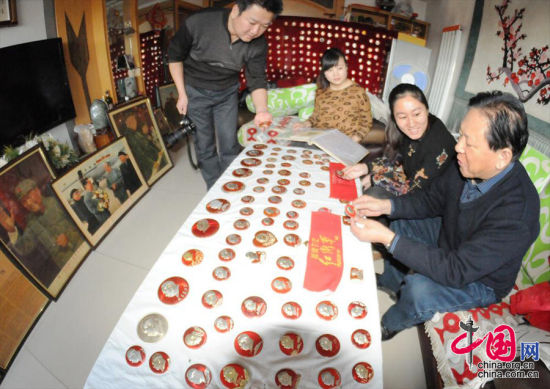 12月24日，收藏家曾继红在家中向参观和欣赏他收藏毛泽东同志的20000枚像章、画像、雕塑和工艺品的群众介绍展品中国网图片库王将摄影