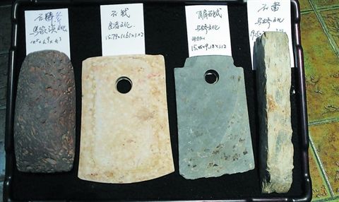 四件捐赠品从左至右分别为：马家浜文化石斧，良渚文化石钺，马桥文化有肩石钺和石凿。