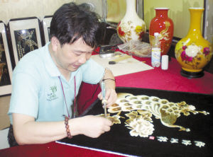 “非遗”传承人蔡照普正在创作麦草艺画