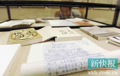 2012年10月25日，参观者在观看莫言手稿及作品签名本。新华社发
