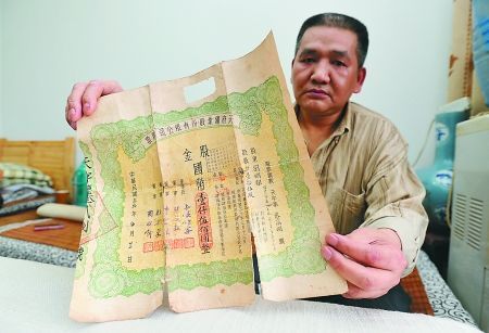 江北区，张朝华展示他收藏的老股票。记者 吴珊 摄 