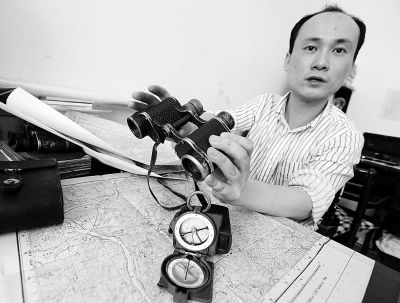 黄老师展示他收藏的抗战时期军用地图、望远镜和指南针。 记者何晓刚 摄