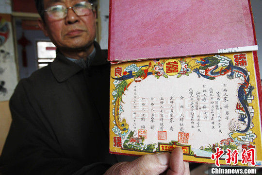 3月19日，河南开封证书收藏老人张洪军展示1948年的结婚证，上面印有“鸾凤和鸣”字样，边饰华丽、精致。中新社发 王中举 摄