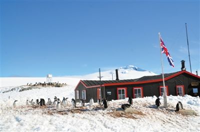 当年科考站的工作间是铁皮木屋，咖啡色。周围已被企鹅们占领，国旗的守卫任务也已由“企鹅国旗班”接管。