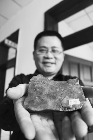 吴文盛馆长手捧珍贵的石陨石。 