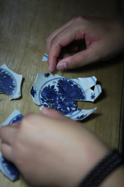 考古工作者对出土青花瓷片进行修复​