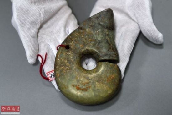 工作人员向记者展示追回的文物—红山文化玉猪龙（4月10日摄）