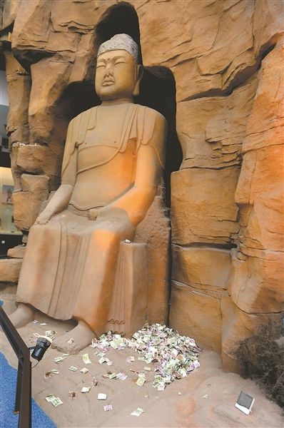 博物馆多尊佛像身上被扔钱币