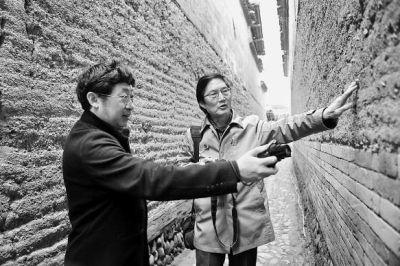 专家在踏勘下梅村一处古民居外墙。