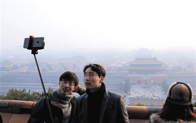 1月13日，景山峰顶，游客在雾霾中用自拍神器留影。