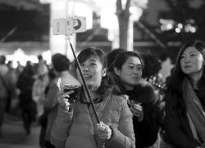 在夫子庙，一名游客使用自拍杆拍照