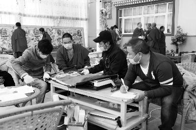 2014年9月，青海省果洛州甘德县龙恩寺内，普查队员和僧侣认真开展可移动文物普查工作。