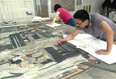专家正在进行古书画装裱修复。故宫的“古书画装裱修复技术”被列为“国家级非物质文化遗产”。资料图片/受访者提供