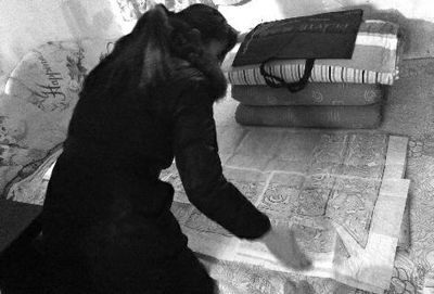 1月4日，昭陵博物馆内一经营工艺品的女子在商店隔间的小屋内，悄悄向游客展示尉迟敬德和程咬金的墓志志石拓片 佘樱 摄