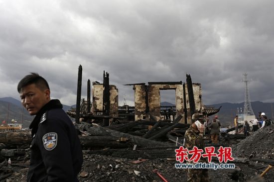 1月5日，大理巍山古城，警察在现场勘查，大火后的拱辰楼二楼仅剩下几根已成焦炭的木柱子。 早报记者 程艺辉 图