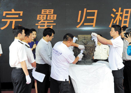 图为仪式现场，工作人员对皿方罍器身进行查验。资料图片