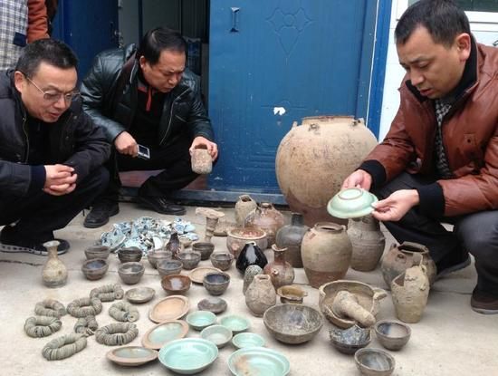 12月8日，上海市文物局，上海海关副关长史济越（左）与上海市文物局副局长褚晓波（中）查看移交的文物。 澎湃新闻记者 杨博 图
