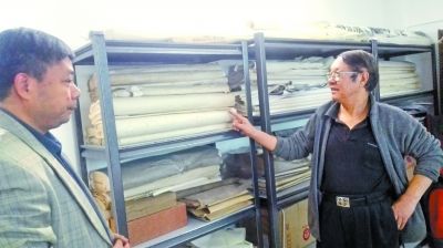 刘书民向评论家胡红拴展示其十几年前在红星厂定制的防伪宣纸。