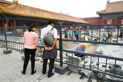昨日，故宫乾清门广场，游客正在近距离观看地面铺墁工艺。