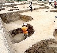 考古工作人员在发掘工地清理灰坑。中新社发 杨正华 摄 