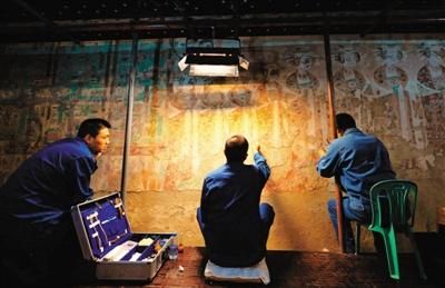 9月3日，三名技术人员在莫高窟98窟内对病害壁画进行修复。