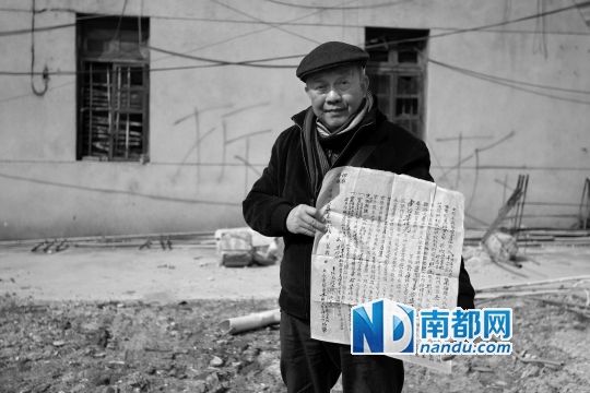 2013年12月21日，妙高台3号业主之一陈祖沛，手持屋契站在被拆房屋原址上。 南都记者 谭庆驹 摄