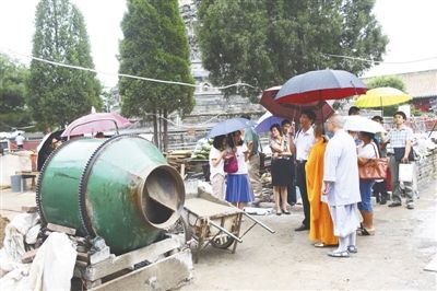 文物局执法人员查看寺内的违章建筑施工情况。本版摄影  新京报记者 浦峰