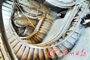 陈廉伯旧居内螺旋楼梯，可以看出栏杆等构件受损严重。 记者黎旭阳摄