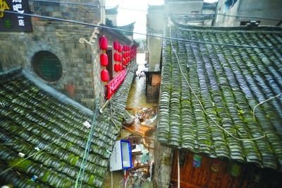 16日中午，湖南凤凰古城江边一些商铺的财产被大水冲出门外，损毁严重 　　特派记者 胡琴沁 发自湖南凤凰古城