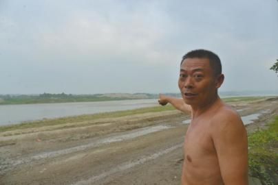 村民手指正前江中，即“陈国林乌木案”发现处。
