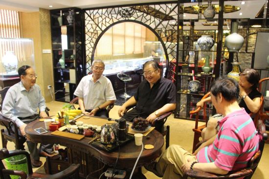各位中华文化促进会领导在指引收藏展厅品茶并鉴赏藏品