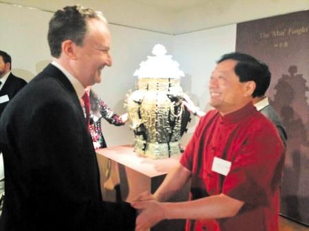昨日，在美国纽约举行的皿方罍器身交接仪式上，湖南省博物馆馆长陈建明（右）与美方人员握手。老谭 摄