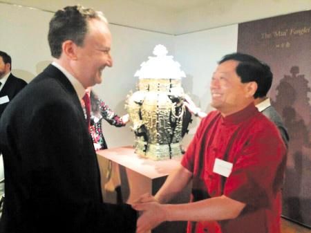 昨日，在美国纽约举行的皿方罍器身交接仪式上，湖南省博物馆馆长陈建明（右）与美方人员握手。老谭 摄