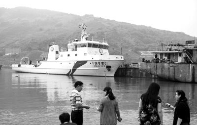 5月19日，几名参观者在重庆长航东风船舶工业公司船舶码头欣赏“中国考古01”号。