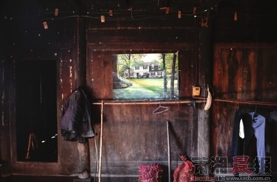 村里一栋明清时期的老房子里贴着新潮的海报，海报上画着西式别墅，让人浮想联翩。