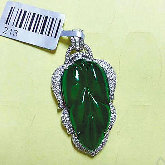 黄纸底、日光灯下的同一块翡翠