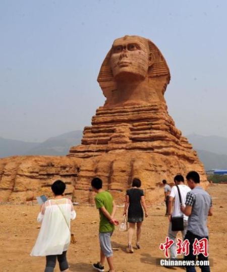 5月21日，顶着炎炎烈日，前来参观“狮身人面像”的市民却络绎不绝。