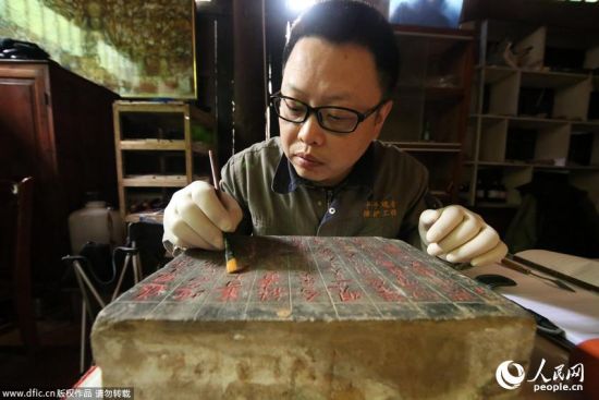 2014年5月8日，重庆市大足区宝顶山千手观音造像抢救性保护工程现场，工作人员对主尊造像腹部“暗格”进行考察研究。