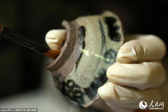 2014年5月8日，重庆市大足区宝顶山千手观音造像抢救性保护工程现场，工作人员对主尊造像腹部“暗格”进行考察研究。