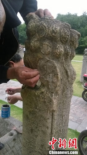 工作人员正在修补被破坏的拴马桩　唐韵　摄