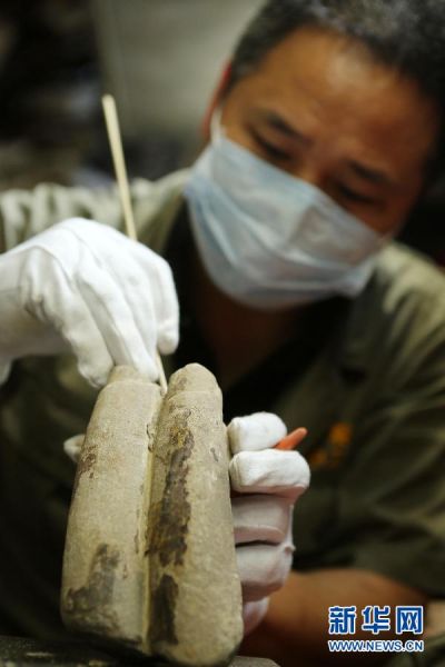 5月16日，工作人员对“暗格”新发现的残缺石质手指进行清洁。