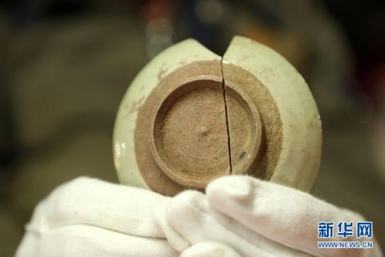 重庆市大足区宝顶山千手观音造像“暗格”新发现的瓷器残片（右侧），可与之前发现的一件瓷器残片（左侧）拼接为一个较完整的瓷碗（5月16日摄）。