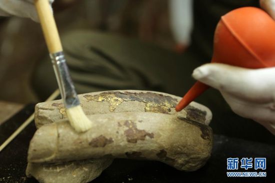 5月16日，工作人员对“暗格”新发现的残缺石质手指进行清洁。