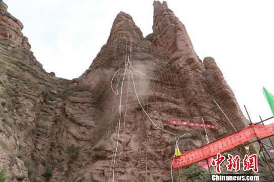  5月16日，炳灵寺石窟景区内，工人们正攀爬在岩体上进行加固作业。据悉，2014年4月该所启动了危岩体治理保护项目，对炳灵寺石窟文物保护区内的姊妹峰及环形道路两侧分布的危岩体进行加固，并对172窟的渗水点进行治理