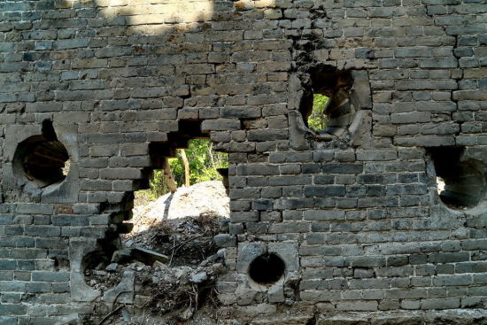 159号敌楼外侧围墙上布满了不规则的望孔（射孔），用于瞭望或射击，内大外小，用形制梯形砖镶砌。供图：CFP