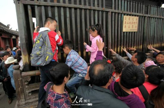 2014年4月5日，湖北武当山景区，部分游客无视景区警示牌子，随意攀爬文物。