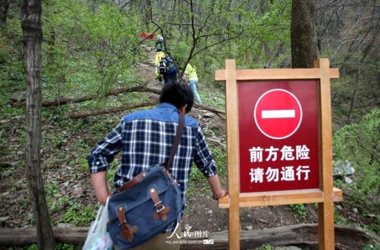2014年4月5日，湖北武当山景区，部分游客无视景区警示牌子，随意攀爬文物。